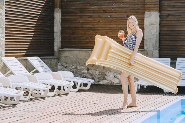 Mädchen in der Nähe eines Pools. Frau in einem stilvollen Badeanzug. Dame in den Sommerferien