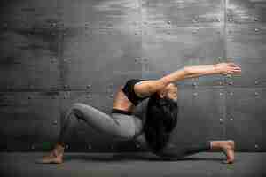 Kostenloses Foto mädchen in der turnhalle, die yoga tut