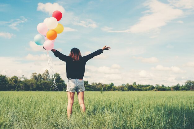 Mädchen in einem Feld mit Luftballons