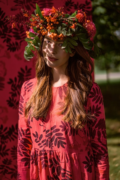 Mädchen in einem Leinenkleid. mit einem Blumenkranz auf dem Kopf.