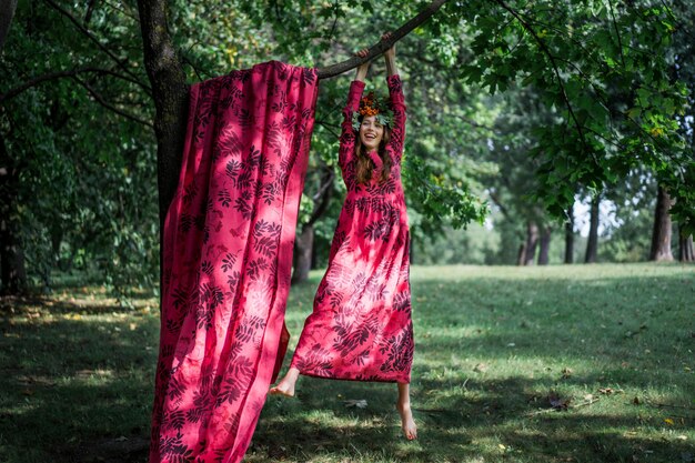 Mädchen in einem Leinenkleid. mit einem Blumenkranz auf dem Kopf.