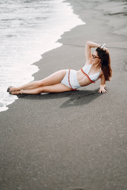 Mädchen in einem stilvollen Badeanzug haben eine Pause am Strand