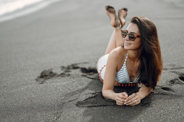 Mädchen in einem stilvollen Badeanzug haben eine Pause am Strand