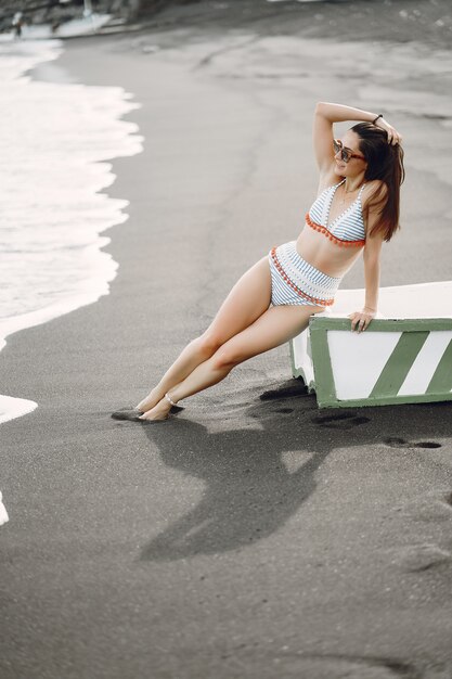 Mädchen in einem stilvollen Badeanzug haben eine Pause am Strand