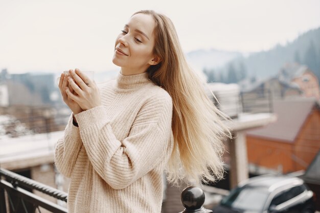 Mädchen in einem warmen hellen Mantel. Urlaub in den Bergen. Dame mit langen Haaren.