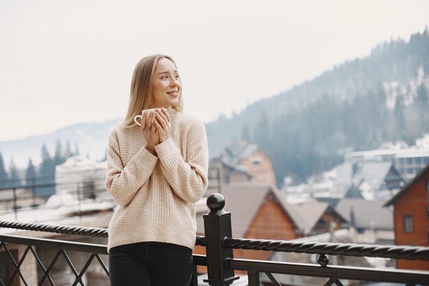 Mädchen in einem warmen hellen Mantel. Urlaub in den Bergen. Dame mit langen Haaren.