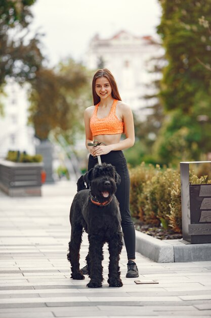 Mädchen in einer Sommerstadt mit Hund