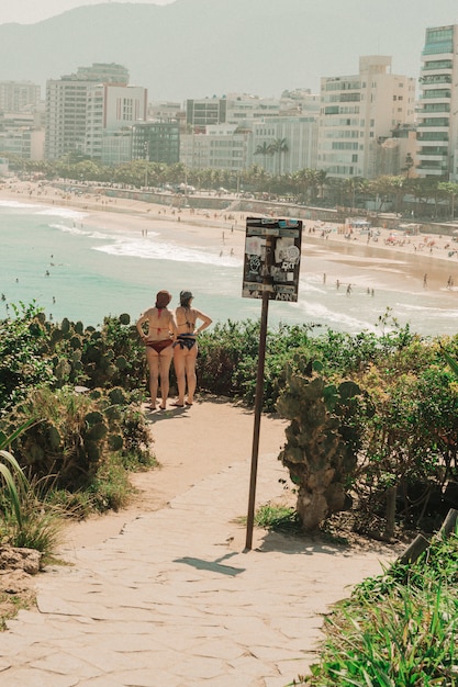 Mädchen in ihrem Bikini, der zum Strand in Rio de Janeiro steht und schaut