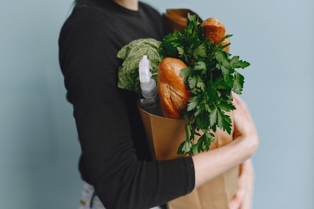 Mädchen in Schutzmaske hält Paket mit Produkten