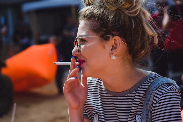 Kostenloses Foto mädchen in vintage sonnenbrille mit tattoos porträt nahaufnahme auf der straße während eines picknicks mit freunden. chill-mädchen