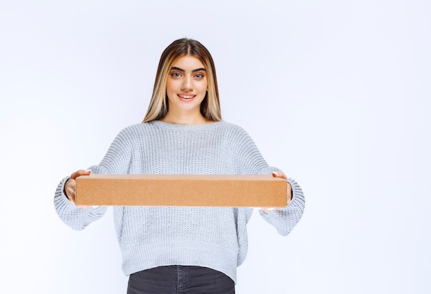 Kostenloses Foto mädchen lieferte dem kunden ein papppaket.