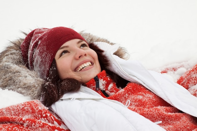 Kostenloses Foto mädchen liegt auf schnee