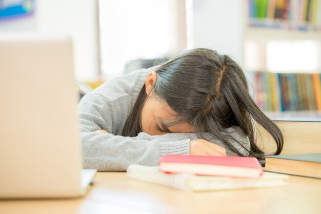 Mädchen machen ein Nickerchen, während sie Bücher lesen