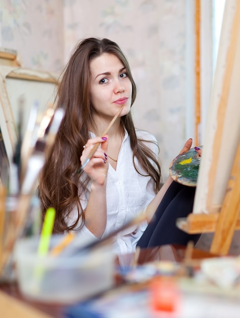 Mädchen malt mit Ölfarben und Pinseln