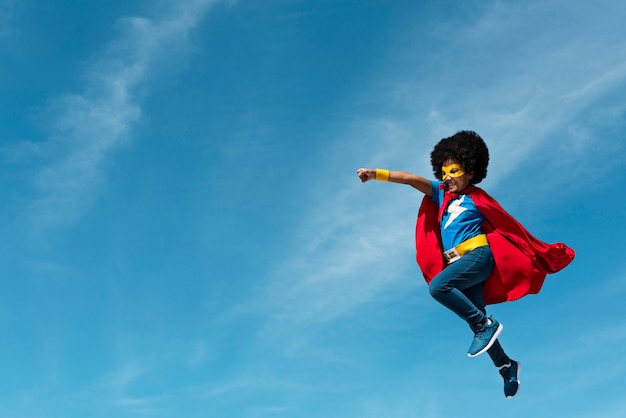 Mädchen mit Afro, der Superheld spielt