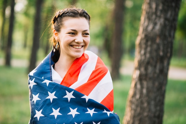 Mädchen mit amerikanischer Flagge vor Baum