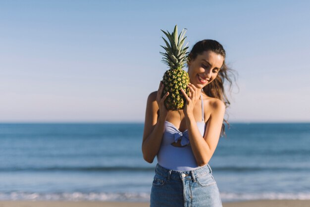 Mädchen mit Ananas am Strand