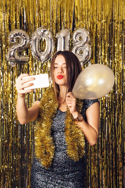 Kostenloses Foto mädchen mit ballon nehmen selfie auf silvesterparty