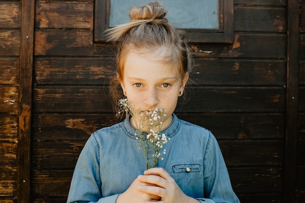 Kostenloses Foto mädchen mit blumen in der nähe von schuppen