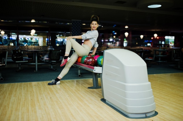 Mädchen mit bowlingkugel auf der gasse spielte im bowlingclub