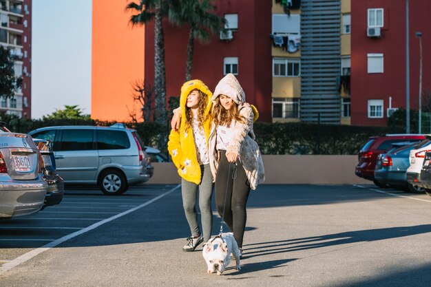 Mädchen mit dem Hund, der auf Parkplatz geht