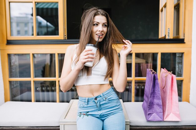 Mädchen mit dem Kaffee, der nach dem Einkauf stillsteht