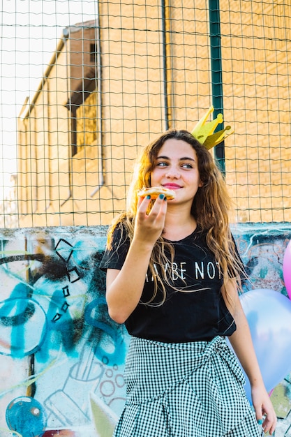 Mädchen mit der Krone, die Geburtstagsgebäck hält