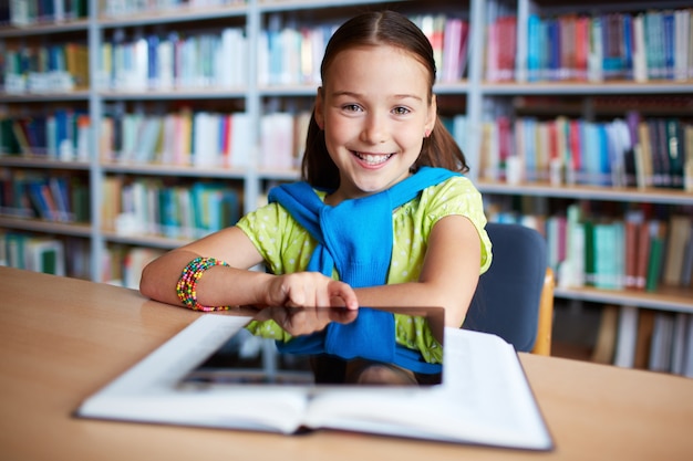 Mädchen mit digitalen Tablette in der Bibliothek