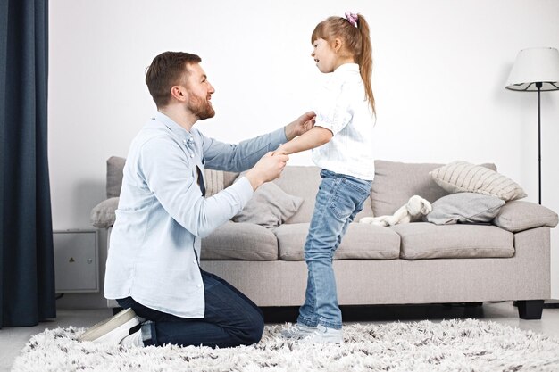 Mädchen mit Down-Syndrom und ihr Vater sitzen auf einem Boden und reden miteinander