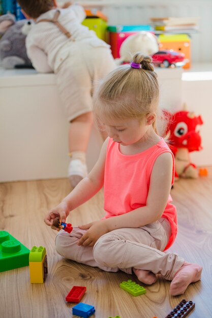 Mädchen mit Flechte spielen auf dem Boden