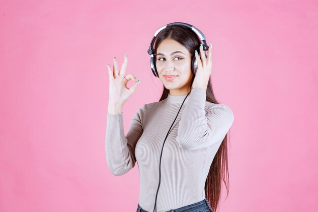 Mädchen mit Kopfhörern, die die Musik hören und ihren Genuss zeigen