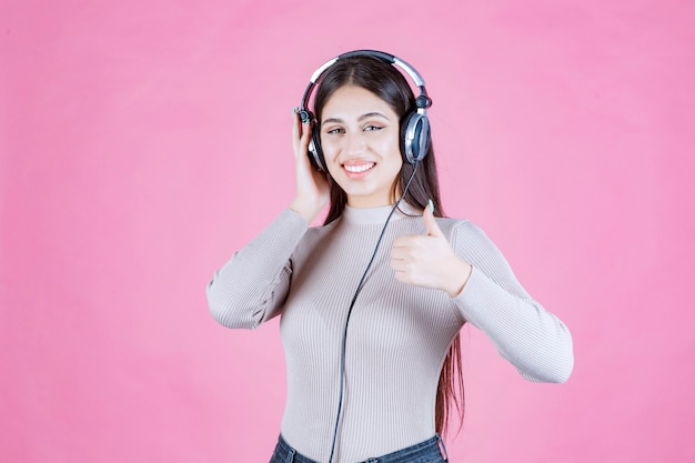 Mädchen mit Kopfhörern, die die Musik hören und ihren Genuss zeigen