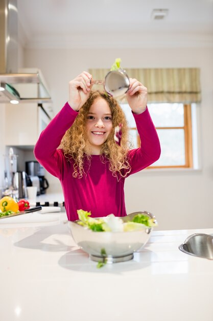 Mädchen mit Kopfsalat im Löffel