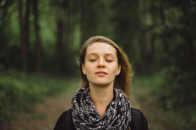 Mädchen mit langen haaren geht durch den wald.