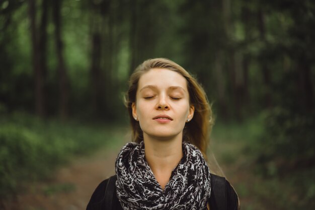 Mädchen mit langen Haaren geht durch den Wald.