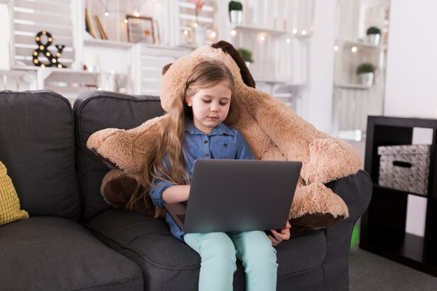 Mädchen mit Laptop auf Couch