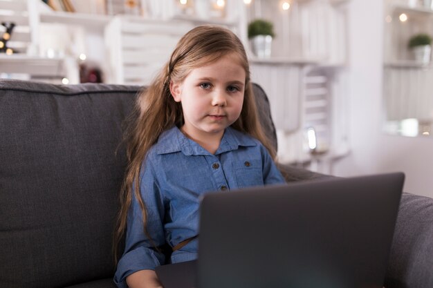 Mädchen mit Laptop auf Sofa