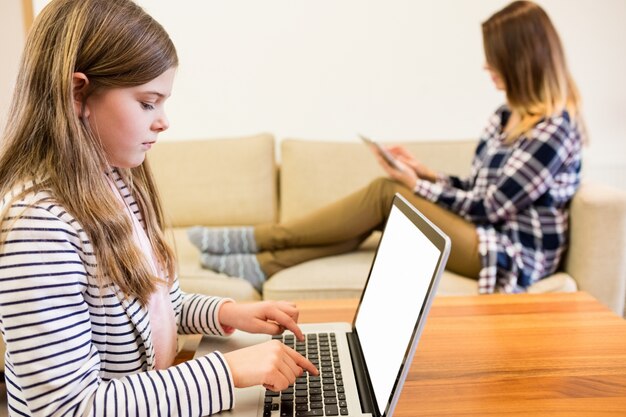 Mädchen mit Laptop im Wohnzimmer