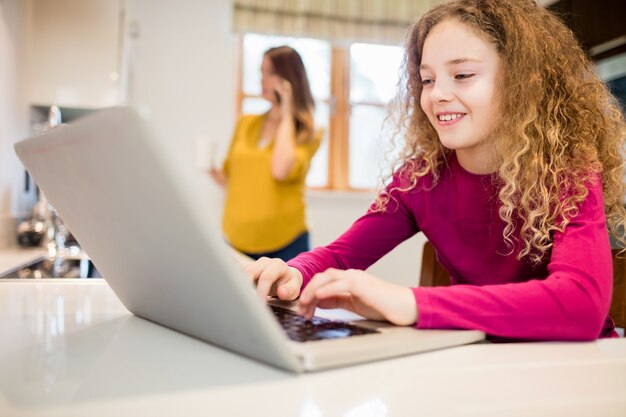 Mädchen mit Laptop in der Küche