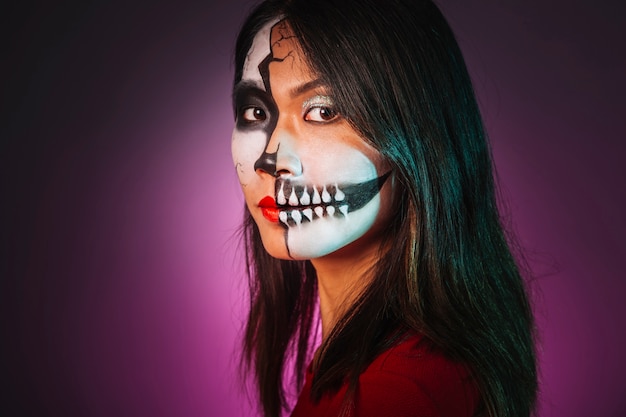 Kostenloses Foto mädchen mit make-up und halloween-maske auf der seite suchen