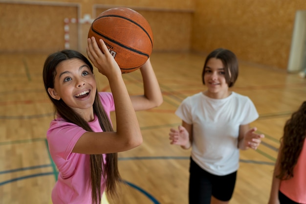 Mädchen mit mittlerem Schuss, das Basketball hält