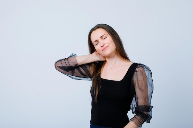 Mädchen mit Nackenschmerzen legt die Hand hinter den Hals auf weißem Hintergrund