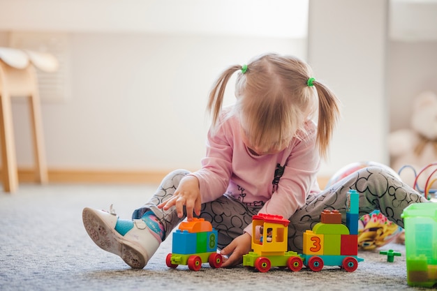 Kostenloses Foto mädchen mit pferdeschwanz spielen mit spielzeug