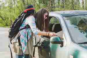 Kostenloses Foto mädchen mit rucksack im gespräch mit einem fahrer