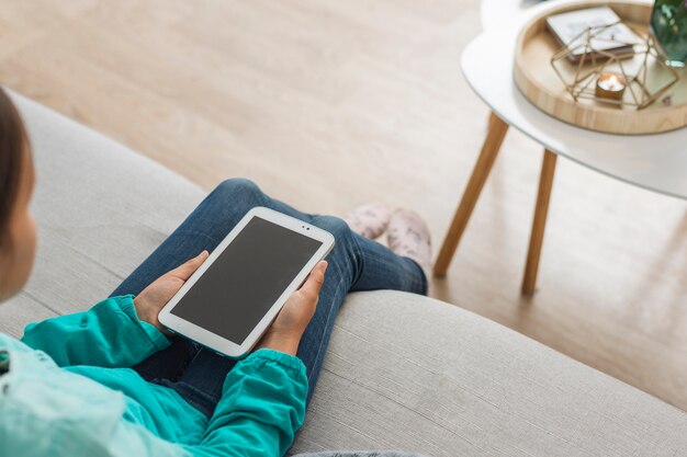 Mädchen mit Smartphoneschablone zu Hause