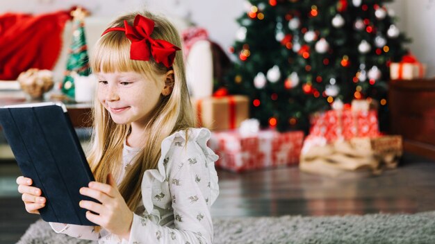 Mädchen mit Tablette am Weihnachten