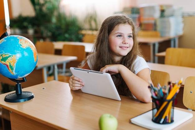 Mädchen mit Tablette im Klassenzimmer