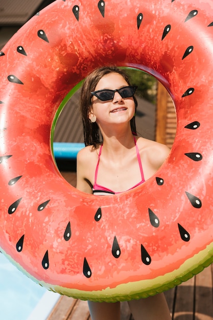 Kostenloses Foto mädchen mit wassermelone floatie mittlerem schuss