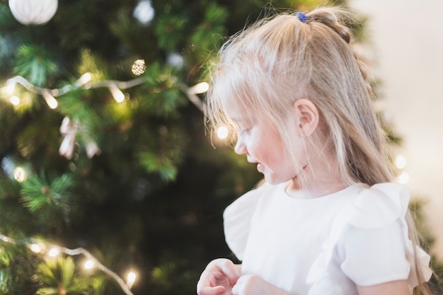 Kostenloses Foto mädchen nahe bei weihnachtsbaum