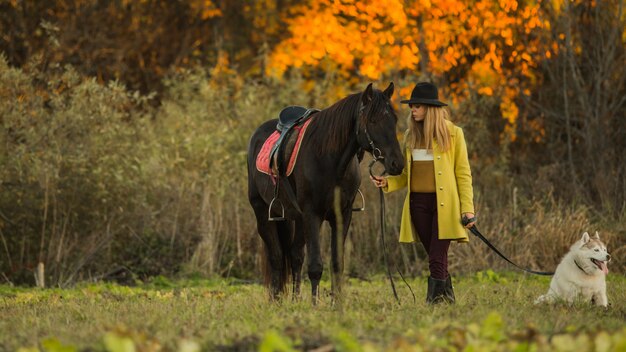 Mädchen posiert mit einem Pferd und einem Hund